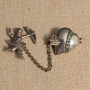 vintage "inseparables" f brooch featuring a cupid and a heart connected by Chain